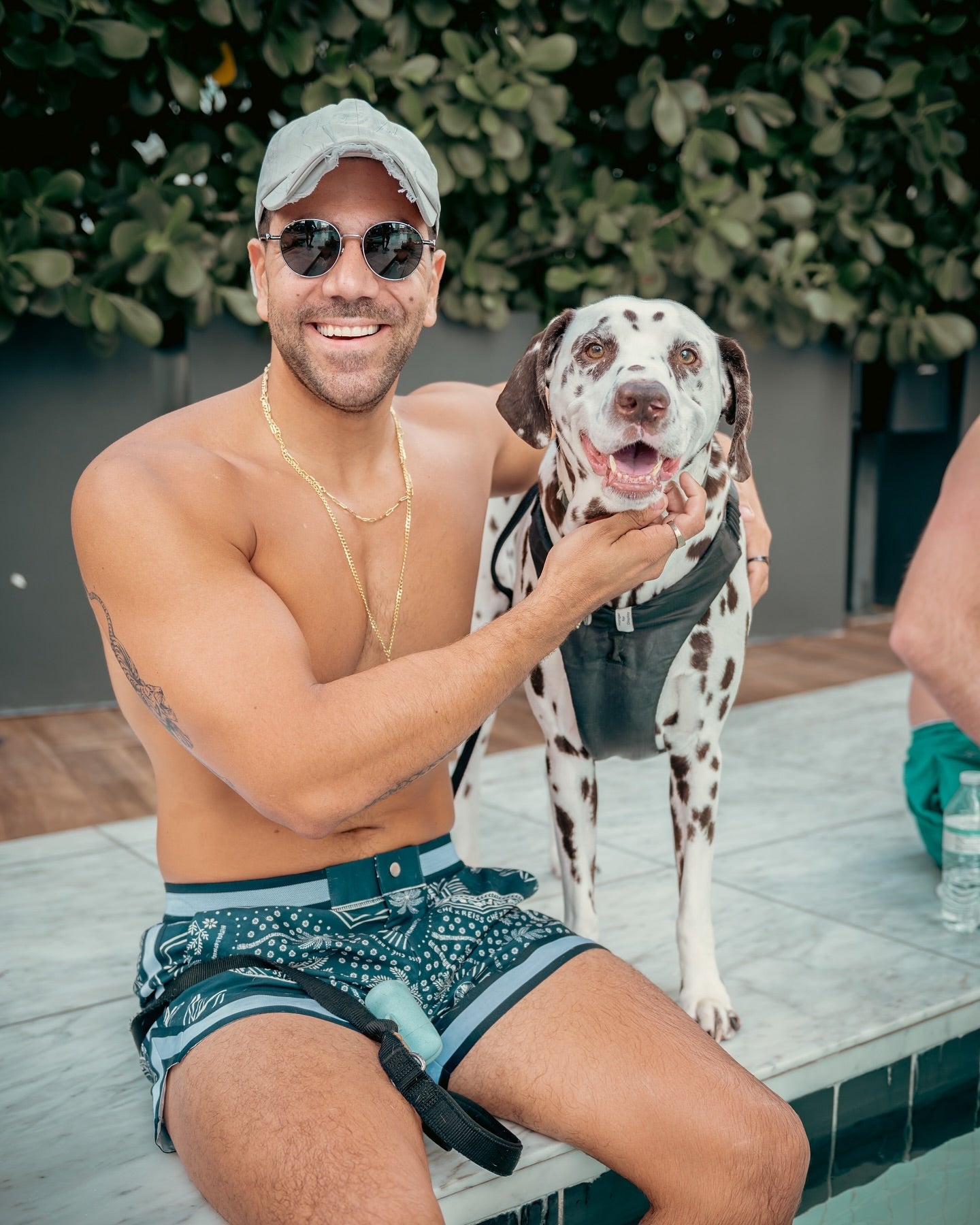 A smiling attendee holding a spotted dog at Pups N Chill