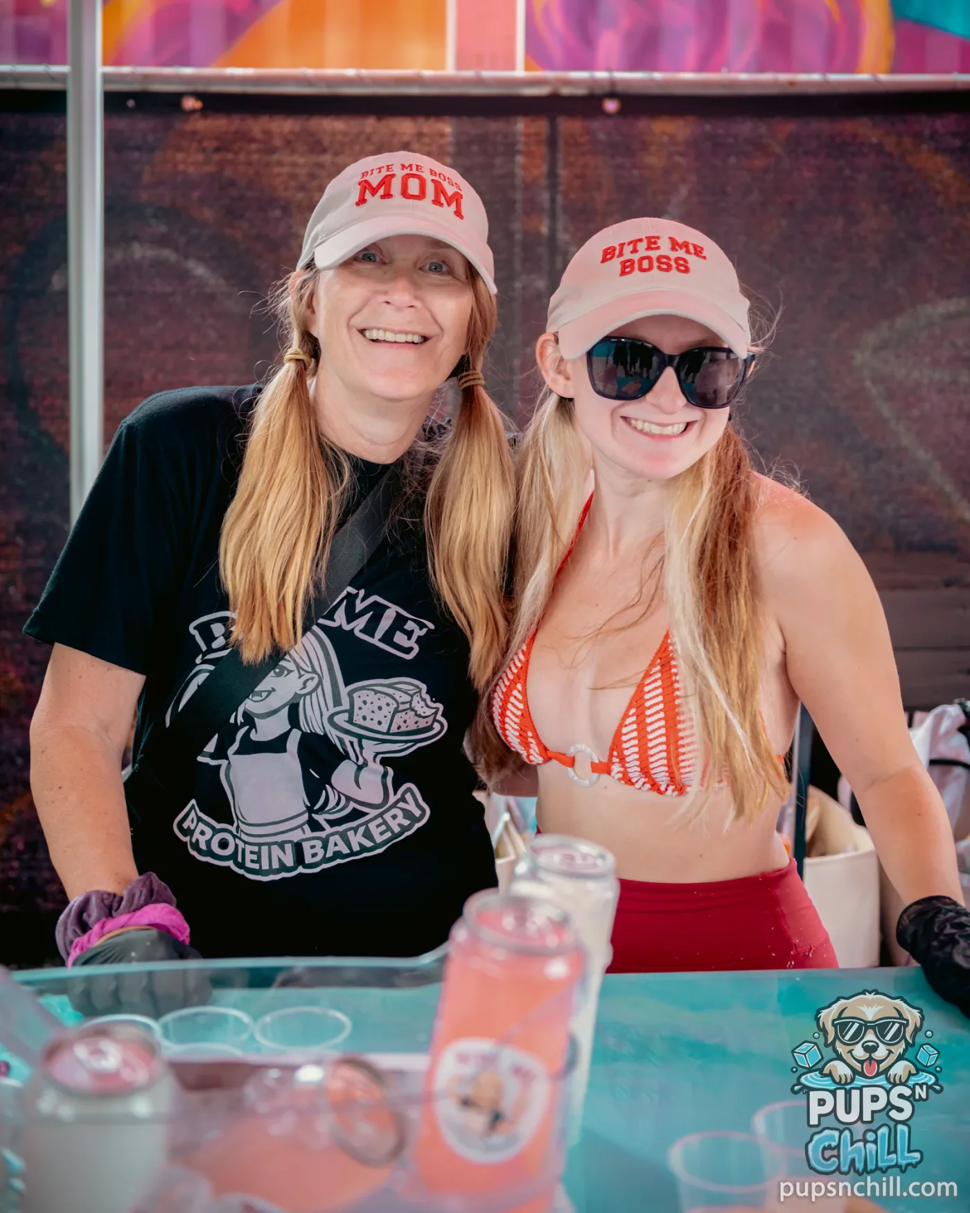 Two smiling vendors at the Bite Me protein bakery booth